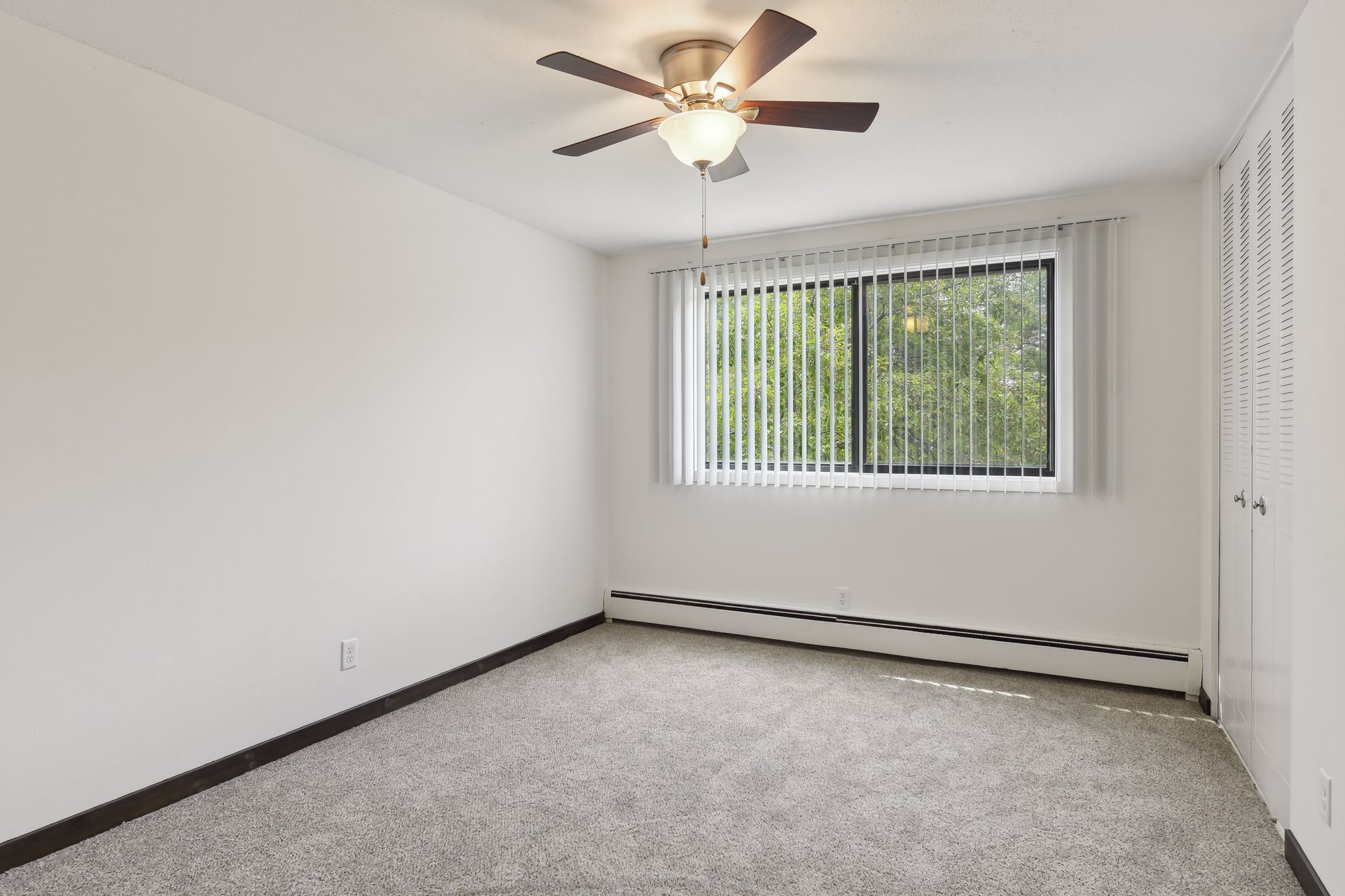 Bedroom with large window and ceiling fan